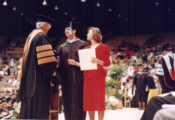 Bobby, escorted by daughter Kimberley, receiving his diploma from Dr. Dwight D. Vines